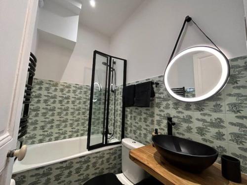 une salle de bain avec un lavabo noir et un miroir dans l'établissement Le Blandan 171. Appartement F2 quartier Nancy-Thermal, à Nancy