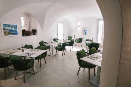 a dining room with tables and green chairs at Palazzo San Rocco Residenza Gentilizia in Sperlonga