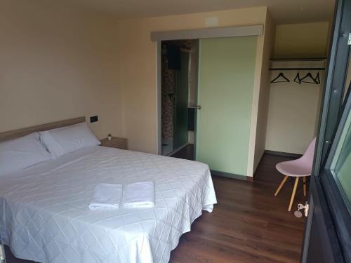ein Schlafzimmer mit einem weißen Bett mit zwei Handtüchern darauf in der Unterkunft Albergue O Corisco in Redondela
