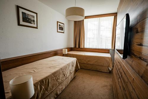 a bedroom with two beds and a window at Šport Hotel *** Donovaly in Donovaly