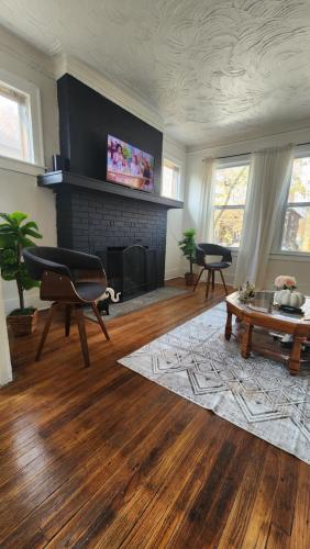 Una sala de estar con chimenea y una mesa. en This Old House, en Detroit