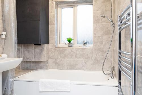 Cozy 1-Bedroom Flat at Abingdon في أوكسفورد: حمام مع حوض استحمام ومغسلة