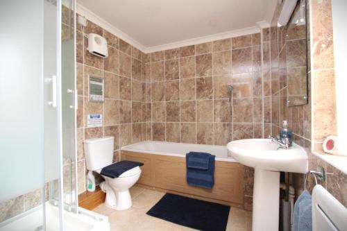 a bathroom with a tub and a toilet and a sink at Blaencwm Cottages in Boncath