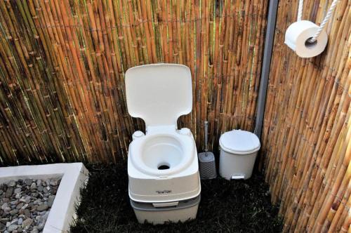 een badkamer met een toilet en een vuilnisbak bij Magic Bus in Kissamos