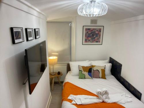 1 dormitorio con 1 cama con manta naranja en Central Point apartment en Londres