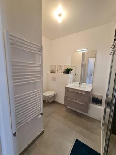 a bathroom with a toilet and a sink and a mirror at Appartement neuf avec balcon/ fibre/parking privé in Massy