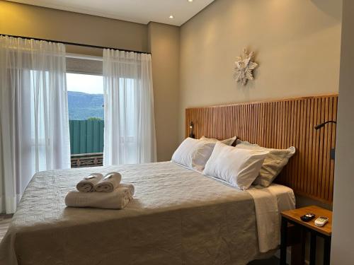 a bedroom with a large bed with towels on it at Pousada Maria Monteiro Tiradentes in Tiradentes
