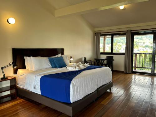 Schlafzimmer mit einem großen Bett mit blauer und weißer Bettwäsche in der Unterkunft Villa Salento Boutique Apartments & Spa in Salento