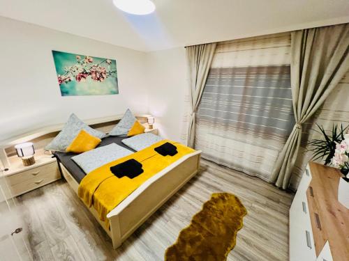 um quarto com uma cama com lençóis amarelos e uma janela em 2 Zimmer Ferienwohnung Denis 2 em Oberwesel