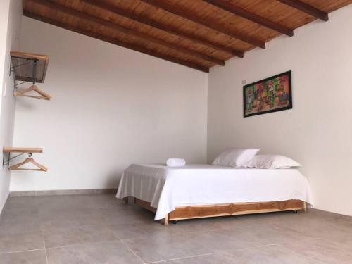 um quarto com uma cama num quarto branco em Coveñas Hermoso Apartamento Vista al Mar em Coveñas