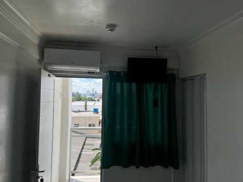a room with a green curtain and a window at Hotel Delavy in Chapecó