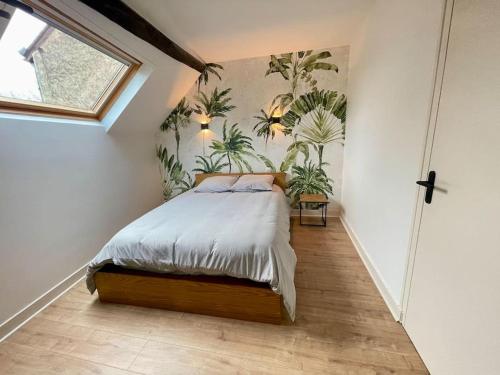 a bedroom with a bed with plants on the wall at Appartement centre ville in Le Blanc