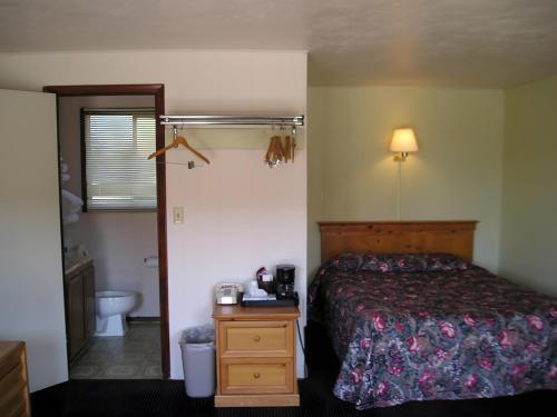 a hotel room with a bed and a bathroom at Yellowstone Country Inn in West Yellowstone