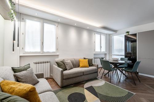 een woonkamer met een bank en een tafel bij StayEasy Argelati40 - Penthouse with 2 bedrooms, 2 bathrooms and terrace - Navigli in Milaan