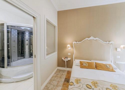 - une chambre avec une baignoire et un lit avec deux oreillers dans l'établissement MILUAR Relais - B&B - Vanvitelli, à Naples