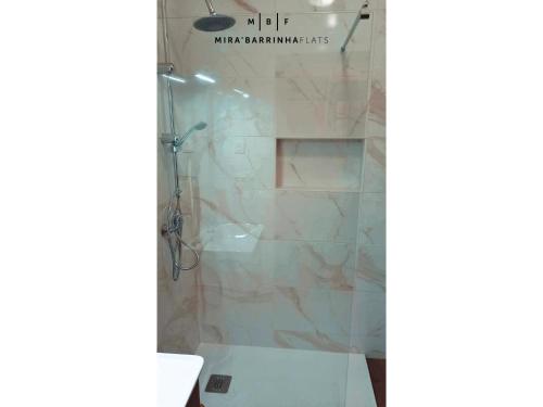a bathroom with a shower with a glass door at Mira'Barrinha Flats in Praia de Mira