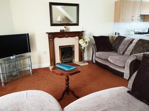 sala de estar con 2 sofás y chimenea en The Annexe, en Bridlington