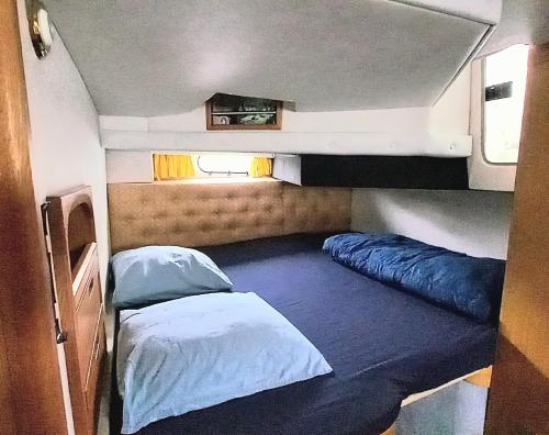 Montalieu-VercieuにあるEden marineのベッド2台と窓が備わる小さな客室です。