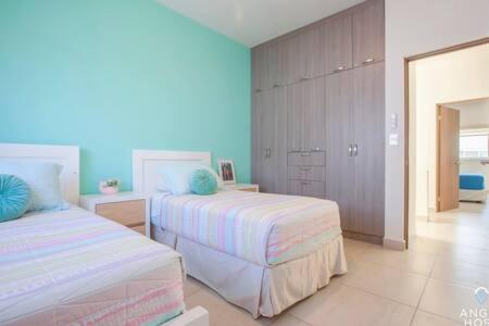a bedroom with two beds and a blue wall at Spacious home with private yard and community pool in La Paz
