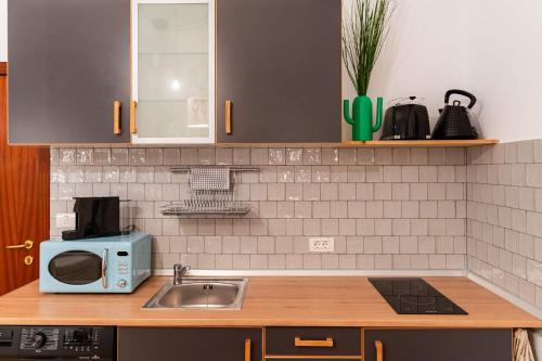 a kitchen counter with a sink and a microwave at Rezident in Bucharest