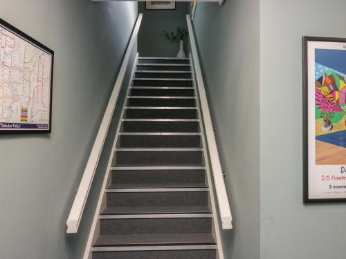 a staircase in a building with a poster on the wall at Helton Fell in Kendal