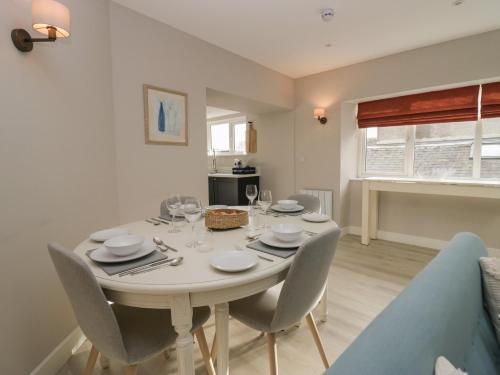 a dining room with a white table and chairs at Helton Fell in Kendal