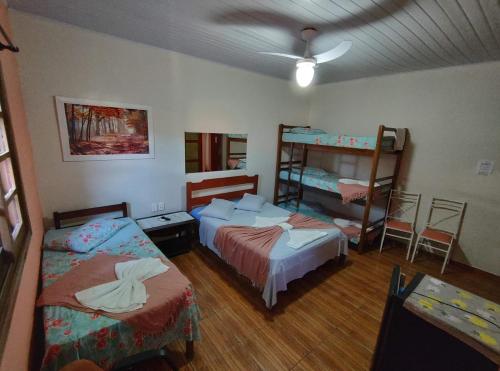 a room with two beds and two bunk beds at Suítes Corais in Ubatuba
