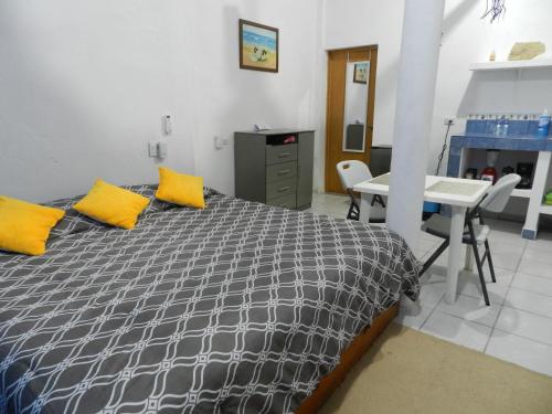 - une chambre avec un lit doté d'oreillers jaunes et d'une table dans l'établissement KayackHouse, à San Carlos