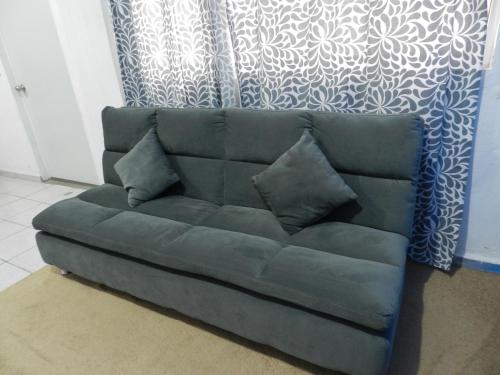 a green couch with pillows in a living room at Casa Kayack in San Carlos