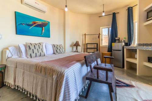 a bedroom with a bed and a chair and a refrigerator at Pacific Villa Punta Mita-Playa Careyeros in Punta Mita