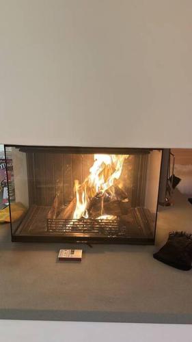 a fire in a fireplace in a living room at Region de Gstaad - Ultra Modern Apartment- Huge Roof Terrace - Great Views in Zweisimmen
