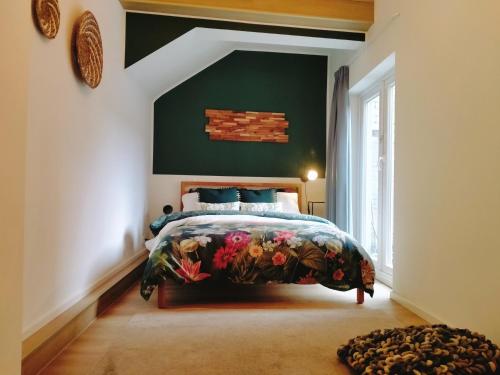 um quarto com uma cama e uma parede verde em Maya sweet rooms em Heerlen