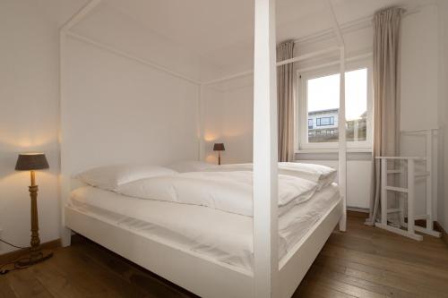 ヘルヌムにあるStrandweg 31の白いベッドルーム(窓付)の白いベッド1台