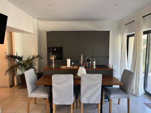 a kitchen and dining room with a wooden table and chairs at Entre Aix et Marseille in Rognac