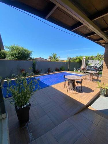 a patio with a table and chairs and a pool at Casa Marques 3 ranchos in Três Ranchos