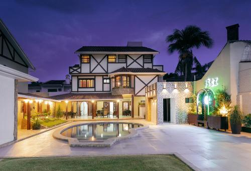 a house with a swimming pool in front of it at Hotel By Armonía Santa Cruz in Santa Cruz de la Sierra