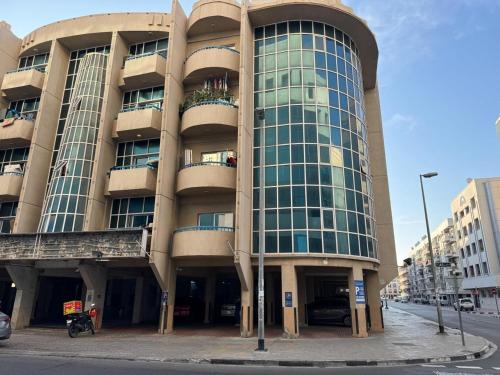 un grand bâtiment avec beaucoup de fenêtres sur une rue dans l'établissement Partition Rooms in Hotel Apartment, à Dubaï