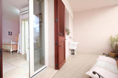 baño con puerta de cristal y lavamanos en Adua Art, en Castrignano del Capo