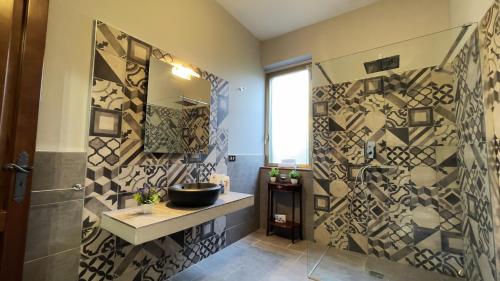 ein Bad mit einem Waschbecken und einem Spiegel in der Unterkunft Country Sicily Home in Favara