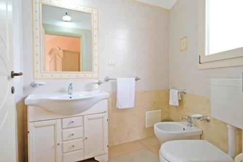 a bathroom with a sink and a toilet and a mirror at Adua Art in Castrignano del Capo