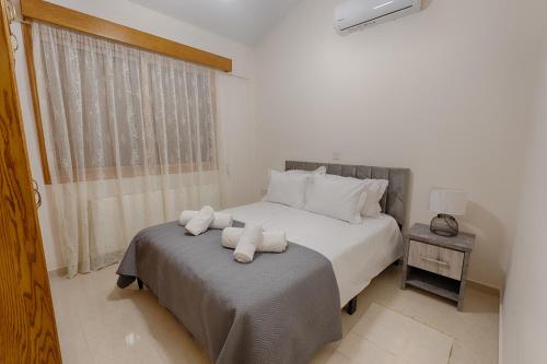 a bedroom with two beds and a window with towels at Eidyllio ''The Mansion'' in Omodos