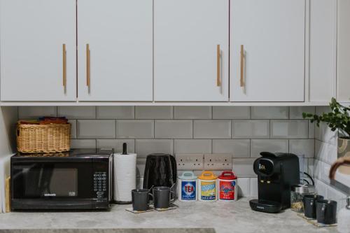 a kitchen counter top with a microwave and a counter top at BlueSeaView Apartment with fabulous sea views in Newcastle