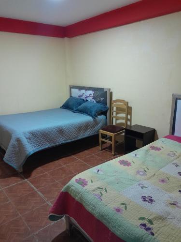 a bedroom with two beds and a chair at Santa Fe in Oruro