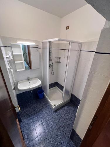 La salle de bains est pourvue d'une douche et d'un lavabo. dans l'établissement Laurel Apartment, à Sienne