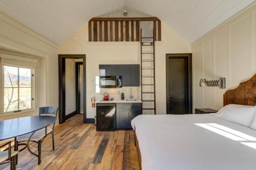a bedroom with a bed and a table and a kitchen at South Main Residences by Surf Hotel in Buena Vista