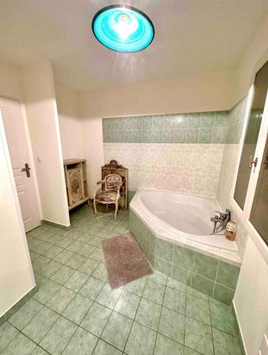 La salle de bains est pourvue d'une baignoire et d'une chaise. dans l'établissement Villa Julien, prox Saint-Tropez, à Gassin