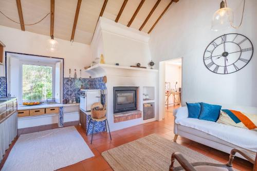 a living room with a couch and a clock on the wall at CASAVADIA melides in Melides