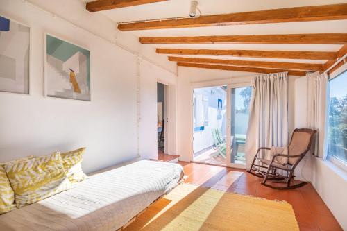 a living room with a white couch and a chair at CASAVADIA melides in Melides