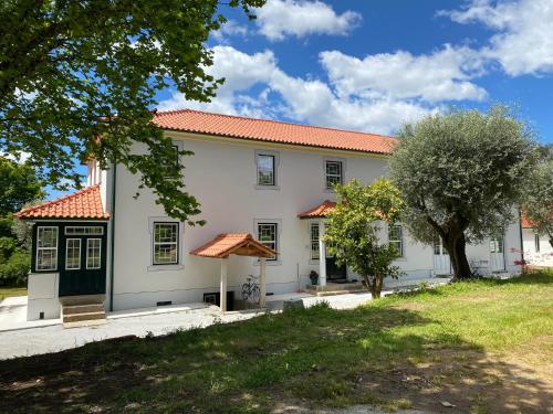 eine Außenansicht eines weißen Hauses mit einem Baum in der Unterkunft Catrinandes - Retreat Center in Tondela