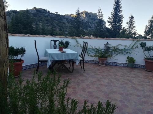 einen Tisch und Stühle auf einer Terrasse mit Bergen im Hintergrund in der Unterkunft VyVE Grazalema AT in Grazalema